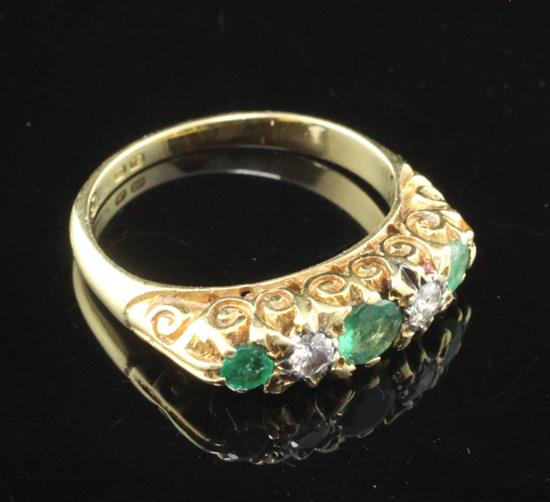 An 18ct gold and graduated five stone emerald and diamond half hoop ring, size K.